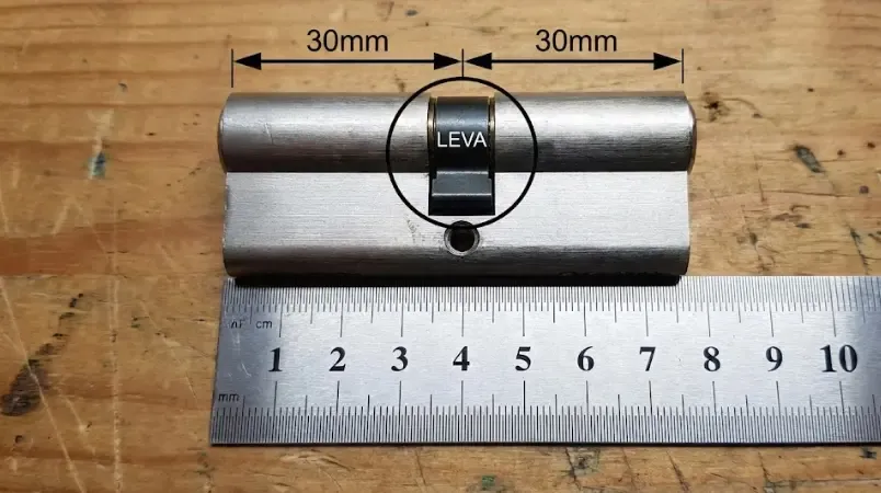 Esquema visual de las medidas de un bombín de cerradura mostrando la distancia desde el tornillo central a los extremos