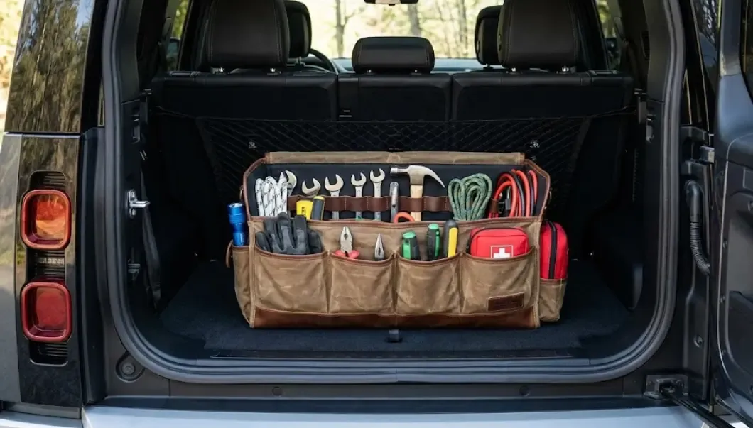 Organizador de tela resistente y rígido lleno de herramientas y accesorios perfectamente colocados en el maletero limpio de un coche oscuro